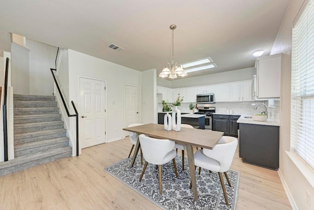 2701 Bolton St, Austin, TX 78748 - dining space with a chandelier, stairs, light wood-style flooring, and baseboards