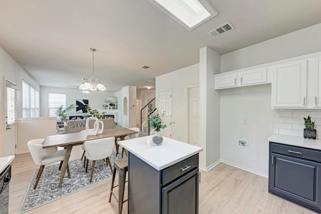 2701 Bolton St, Austin, TX 78748 - kitchen featuring a chandelier, light wood-type flooring, and white cabinetry