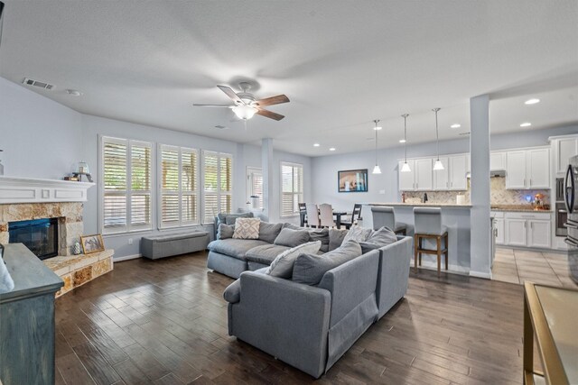 13625 Glen Creek Ct, Manor, TX 78653 - living area with a ceiling fan, a fireplace, dark wood-style floors, recessed lighting, and baseboards