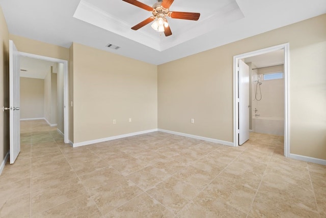 6317 Vida Nueva Ave, Del Valle, TX 78617 - unfurnished bedroom featuring a tray ceiling, light tile patterned flooring, ensuite bath, and ceiling fan