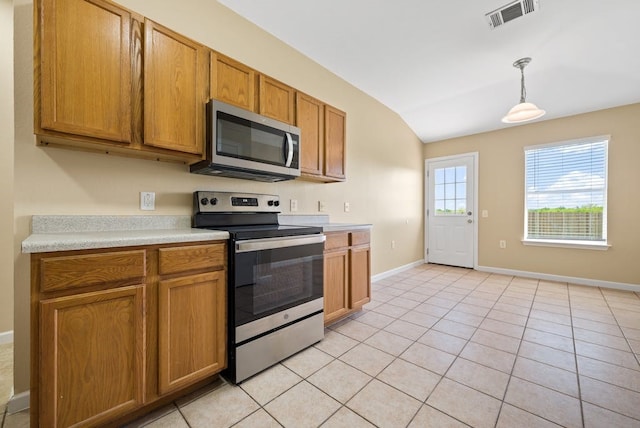 6317 Vida Nueva Ave, Del Valle, TX 78617 - kitchen featuring stainless steel appliances, lofted ceiling, light countertops, brown cabinets, and pendant lighting