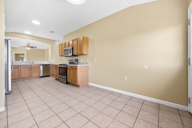 6317 Vida Nueva Ave, Del Valle, TX 78617 - kitchen with stainless steel appliances, light countertops, a ceiling fan, vaulted ceiling, and light tile patterned flooring