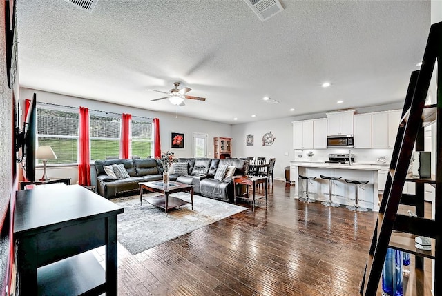 1304 Eagle Ridge Trl, Leander, TX 78641 - living room with ceiling fan, dark wood-style floors, a textured ceiling, and recessed lighting