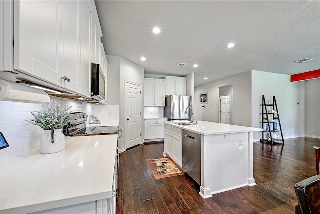 1304 Eagle Ridge Trl, Leander, TX 78641 - kitchen featuring stainless steel appliances, dark wood-style flooring, light countertops, recessed lighting, and white cabinetry
