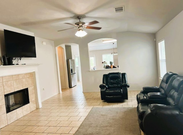 5105 Bantom Woods Bnd, Austin, TX 78724 - living room with a tiled fireplace, arched walkways, ceiling fan, and healthy amount of natural light
