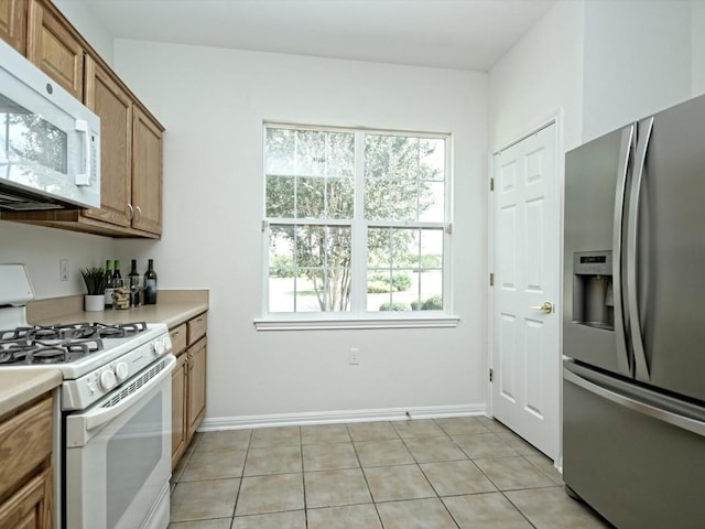 708 Texas Dr, Georgetown, TX 78633 - kitchen featuring white appliances, light countertops, brown cabinets, and light tile patterned floors