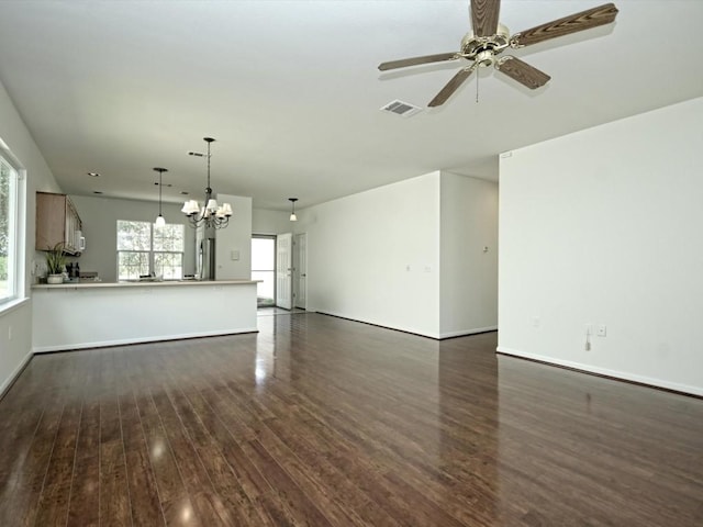 708 Texas Dr, Georgetown, TX 78633 - unfurnished living room with dark wood-style flooring, a ceiling fan, baseboards, and a chandelier