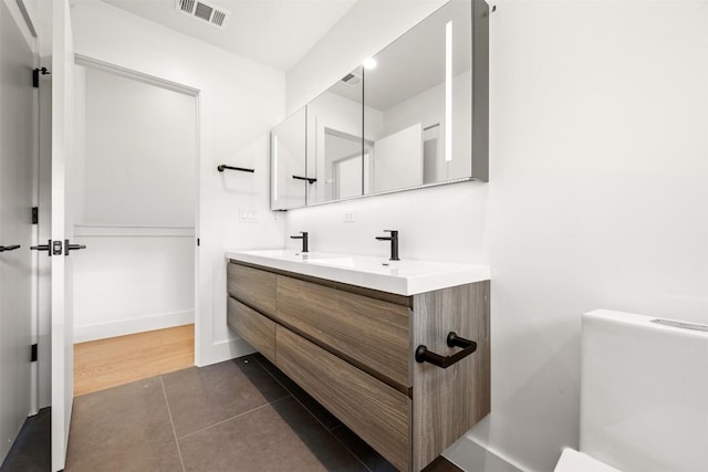 1305 Walnut Ave, Austin, TX 78702 - bathroom with double vanity, tile patterned flooring, and baseboards