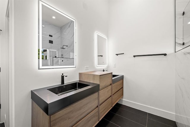 1305 Walnut Ave, Austin, TX 78702 - bathroom featuring double vanity, a marble finish shower, tile patterned floors, and baseboards