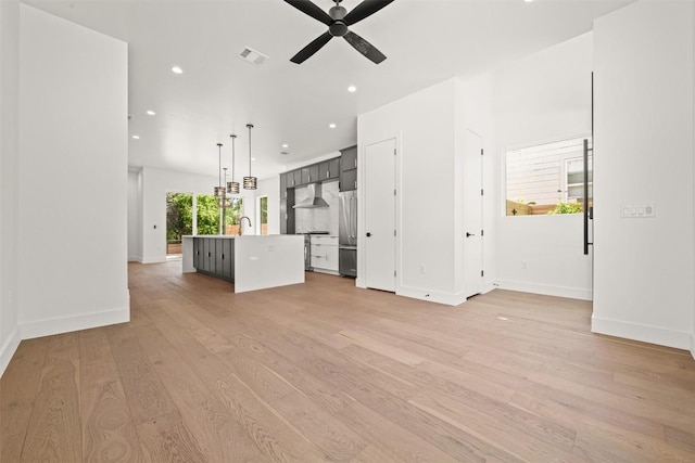 1305 Walnut Ave, Austin, TX 78702 - unfurnished living room with recessed lighting, a ceiling fan, light wood-style flooring, a sink, and baseboards