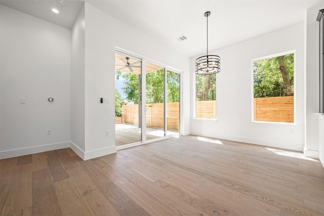 1305 Walnut Ave, Austin, TX 78702 - unfurnished dining area with wood finished floors, healthy amount of natural light, baseboards, and a chandelier