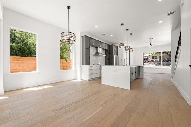 1305 Walnut Ave, Austin, TX 78702 - kitchen featuring exhaust hood, light wood finished floors, healthy amount of natural light, ceiling fan, and recessed lighting