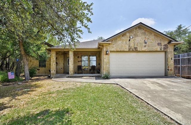 9912 Little Creek Cir, Dripping Springs, TX 78620 - ranch-style home featuring stone siding, an attached garage, driveway, and covered porch