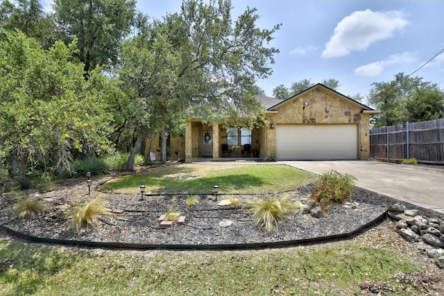 9912 Little Creek Cir, Dripping Springs, TX 78620 - obstructed view of property with stone siding, concrete driveway, and a garage