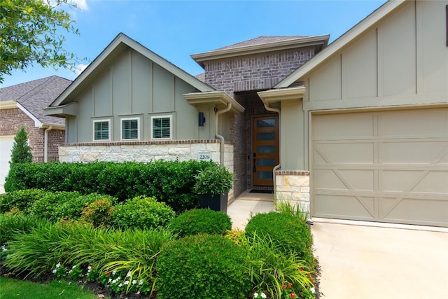 2208 Mcclendon Trl, Leander, TX 78641 - view of front of property with board and batten siding, stone siding, an attached garage, and roof with shingles