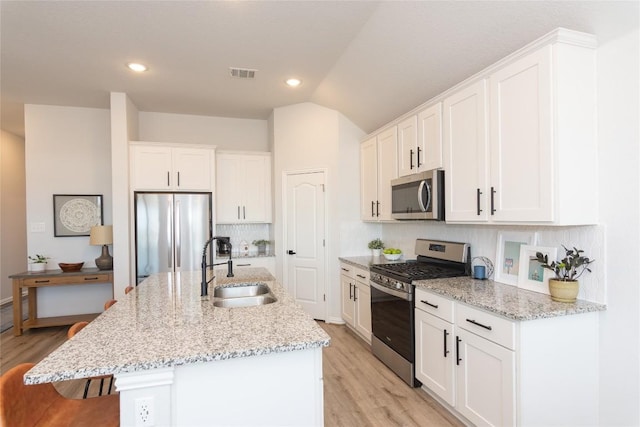 2208 Mcclendon Trl, Leander, TX 78641 - kitchen with appliances with stainless steel finishes, a sink, white cabinetry, tasteful backsplash, and lofted ceiling