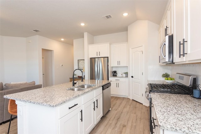 2208 Mcclendon Trl, Leander, TX 78641 - kitchen with appliances with stainless steel finishes, a sink, light wood-style flooring, white cabinets, and recessed lighting