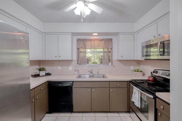 7400 Ophelia Dr, Austin, TX 78752 - kitchen with stainless steel appliances, a sink, light countertops, white cabinetry, and a textured ceiling