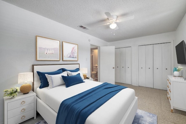 7400 Ophelia Dr, Austin, TX 78752 - bedroom featuring two closets, a textured ceiling, ensuite bathroom, carpet floors, and ceiling fan