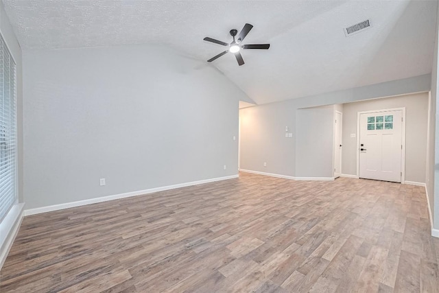7614 Andiron Cir, Houston, TX 77041 - unfurnished living room with lofted ceiling, a ceiling fan, light wood-style flooring, baseboards, and a textured ceiling