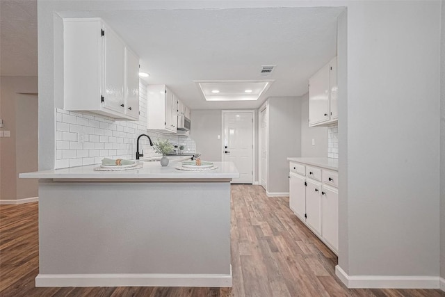 7614 Andiron Cir, Houston, TX 77041 - kitchen featuring white cabinets, light wood-type flooring, backsplash, and recessed lighting
