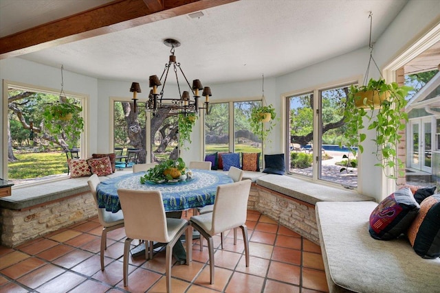 sunroom / solarium featuring a chandelier