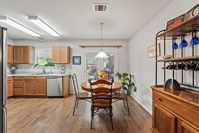 1505 Sedbury Way, Cedar Park, TX 78613 - dining room featuring light wood-style floors, plenty of natural light, baseboards, and a textured ceiling