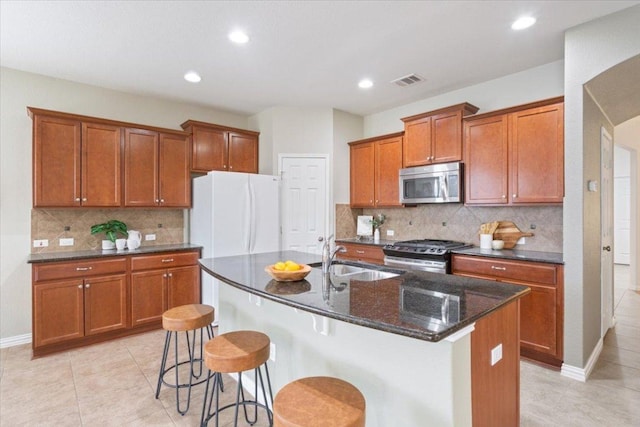 3408 Glastonbury Trl, Pflugerville, TX 78660 - kitchen featuring stainless steel appliances, a sink, brown cabinets, light tile patterned floors, and tasteful backsplash