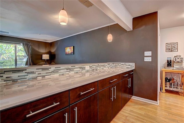 1706 Ridgemont Dr, Austin, TX 78723 - kitchen featuring light wood finished floors, decorative backsplash, light countertops, baseboards, and decorative light fixtures