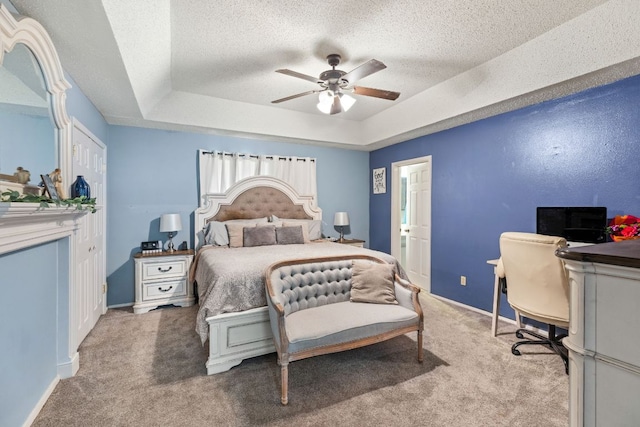 116 S Hackberry Ave, Luling, TX 78648 - bedroom featuring a tray ceiling, light carpet, a textured ceiling, baseboards, and ceiling fan