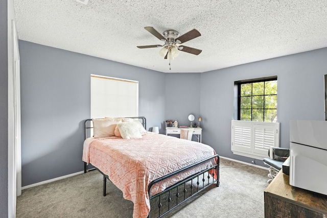 116 S Hackberry Ave, Luling, TX 78648 - bedroom with carpet floors, baseboards, ceiling fan, and a textured ceiling