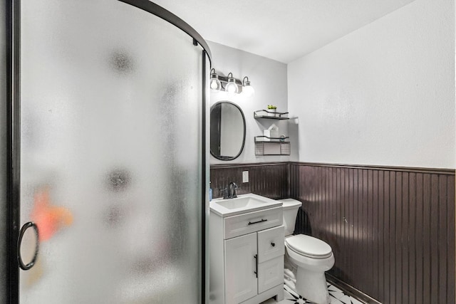 116 S Hackberry Ave, Luling, TX 78648 - bathroom featuring a stall shower, vanity, wainscoting, and toilet