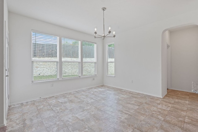 195 Azure Cv, Kyle, TX 78640 - empty room featuring arched walkways, a chandelier, and baseboards
