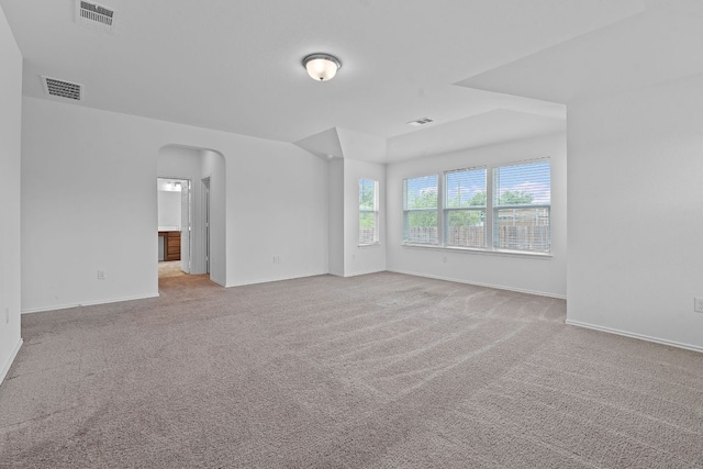 195 Azure Cv, Kyle, TX 78640 - empty room featuring arched walkways, light carpet, and baseboards