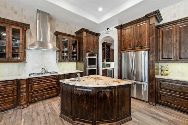 7617 Lazy River Cv, Austin, TX 78730 - kitchen with appliances with stainless steel finishes, wall chimney range hood, wine cooler, light wood-style floors, and dark brown cabinets