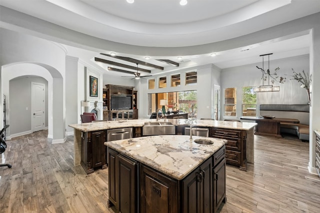 7617 Lazy River Cv, Austin, TX 78730 - kitchen with a kitchen island with sink, arched walkways, a ceiling fan, open floor plan, and recessed lighting