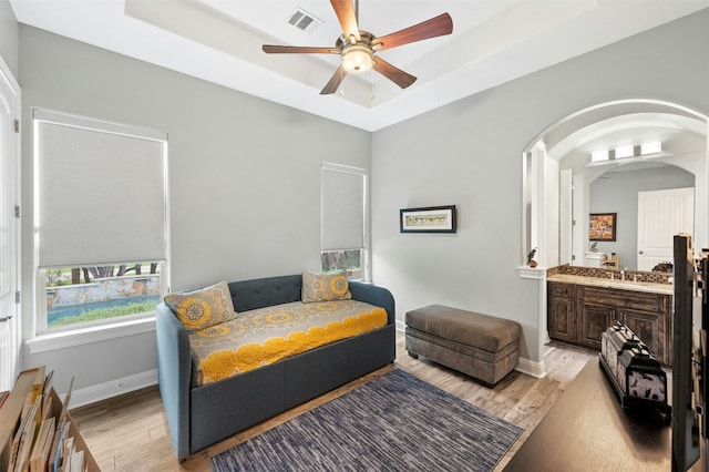 7617 Lazy River Cv, Austin, TX 78730 - bedroom with light wood-style floors, a raised ceiling, arched walkways, a sink, and baseboards