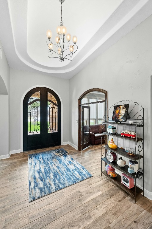 7617 Lazy River Cv, Austin, TX 78730 - entrance foyer featuring arched walkways, french doors, a chandelier, and healthy amount of natural light