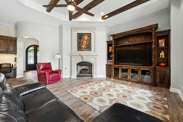 7617 Lazy River Cv, Austin, TX 78730 - living area with ceiling fan, arched walkways, wood finished floors, a fireplace, and beam ceiling