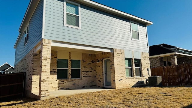 188 Grey Slate Ave, Marble Falls, TX 78654 - back of property featuring brick siding, central AC, and a patio