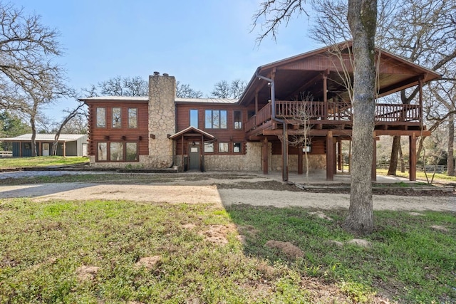 180 Bradley Ln, Rosanky, TX 78953 - view of front facade with stone siding, a chimney, a deck, a metal roof, and a patio