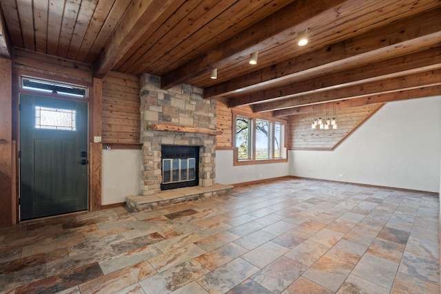 180 Bradley Ln, Rosanky, TX 78953 - unfurnished living room featuring a fireplace, stone tile floors, a wooden ceiling with exposed beams, and track lighting