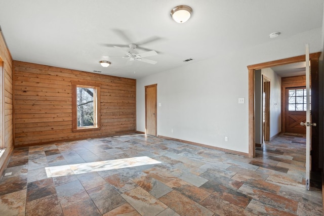 180 Bradley Ln, Rosanky, TX 78953 - spare room with stone tile flooring, ceiling fan, wooden walls, and a smoke detector