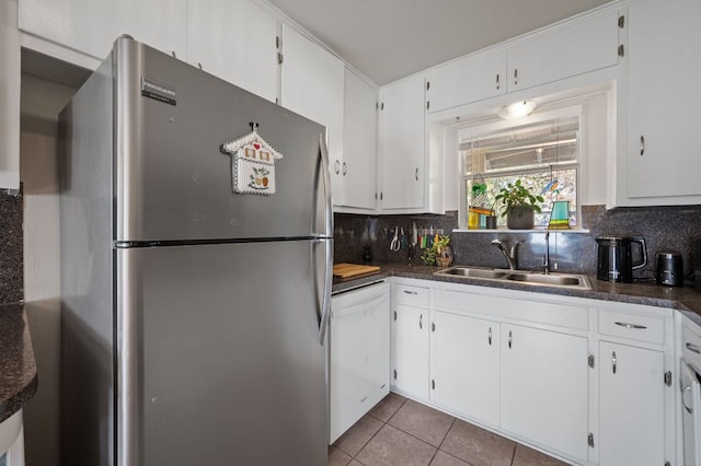 4701 Sylvandale Dr Unit 1, Austin, TX 78745 - kitchen with freestanding refrigerator, white dishwasher, dark countertops, and tasteful backsplash