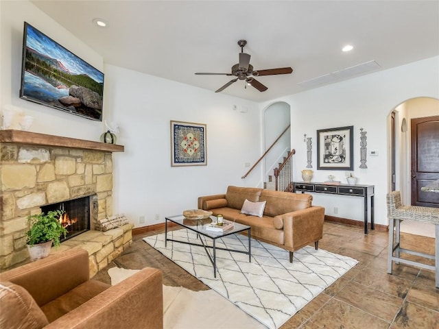 17545 E Reed Parks Rd Unit 5, Jonestown, TX 78645 - living area featuring arched walkways, a fireplace, a ceiling fan, stairs, and baseboards