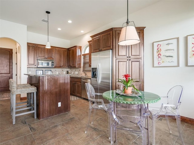 17545 E Reed Parks Rd Unit 5, Jonestown, TX 78645 - kitchen featuring appliances with stainless steel finishes, arched walkways, a center island, backsplash, and recessed lighting