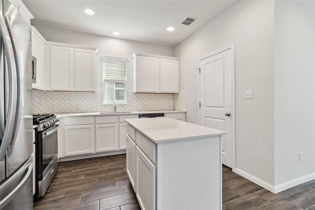 310 Spiny Lizard Ln, San Marcos, TX 78666 - kitchen with stainless steel appliances, backsplash, white cabinets, dark wood-style floors, and light countertops