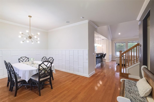 6305 Carrington Dr, Austin, TX 78749 - dining room with a chandelier, ornamental molding, light wood-type flooring, a wainscoted wall, and stairway