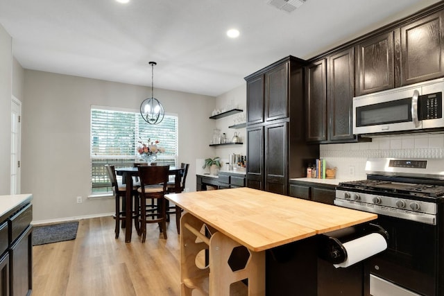 606 Indian Run Dr, Pflugerville, TX 78660 - kitchen featuring stainless steel appliances, wood counters, dark brown cabinets, light wood-style floors, and recessed lighting