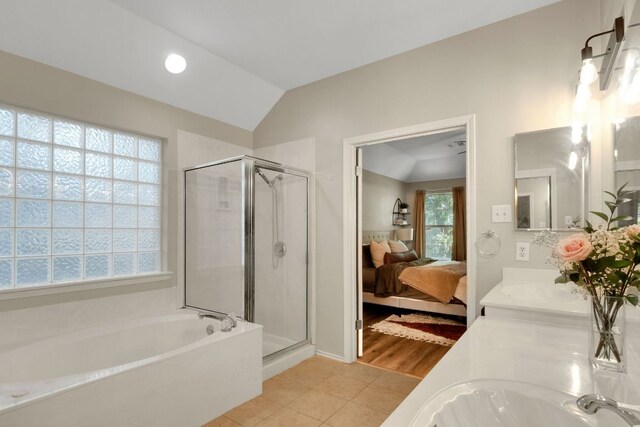 606 Indian Run Dr, Pflugerville, TX 78660 - bathroom with a bath, a stall shower, double vanity, tile patterned flooring, and lofted ceiling